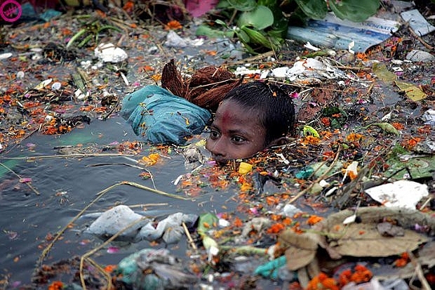 Một cậu bé gặp khó khăn khi bơi qua sông Yamuna - nơi mọi người thường vứt rác xuống